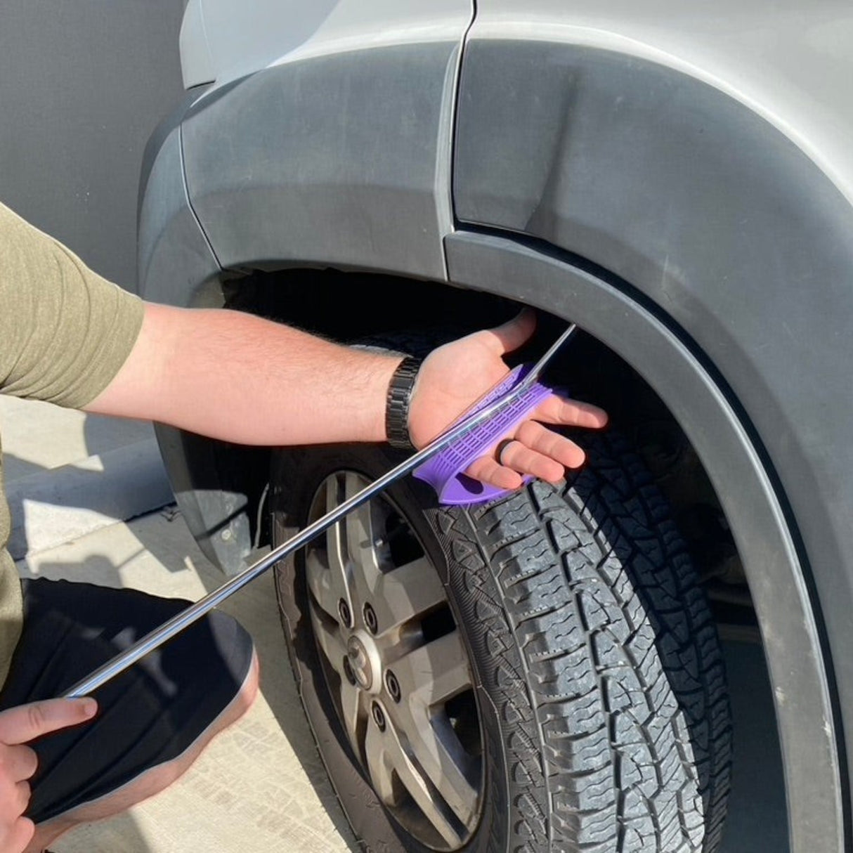 Anson PDR purple hand shield tool protecting hand from car fender and tire during PDR work.