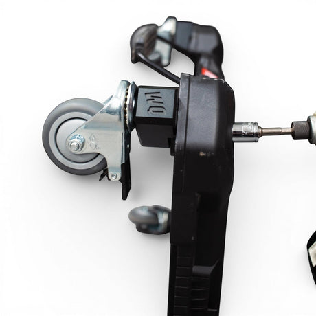 WQ Packout Glideator caster upgrade kit with black mounting blocks and grey wheels, showing installation with a drill.