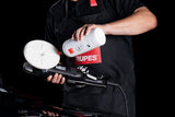Anson PDR technician applying Rupes UNO Pure ultra-fine finishing polish to a white foam pad on a polishing tool.
