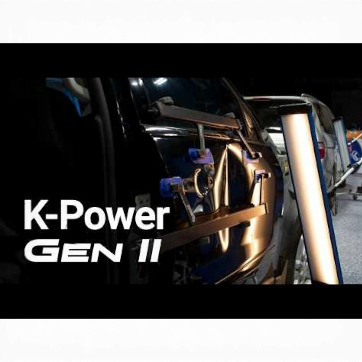 Keco K-Power Mini Gen 2 lateral tension tool on a black car door, used for hail damage repair.